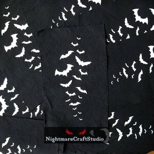 May include: Multiple black fabric squares with white bat silhouettes printed on them. The fabric squares are stacked on top of each other. The text "NightmareCraftStudio" is printed on the bottom of the image.