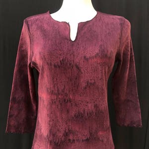 May include: A maroon long-sleeved shirt with a V-neck and a tie-dye pattern.