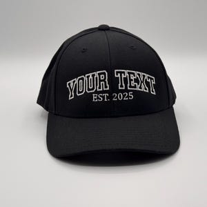 May include: Black baseball cap with white embroidered text that reads "YOUR TEXT EST. 2025".