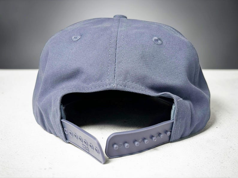 Custom embroidered question mark hat on blue cotton 5 panel snapback cap featuring structured crown and pre curved visor. Clean white embroidery symbol on front panel suitable for custom text, logo placement and daily wear. Adjustable snapback closure provides flexible fit with breathable cotton twill fabric. Product mockup shows front view on neutral background highlighting stitching detail, panel structure and consistent composition for all listing images.