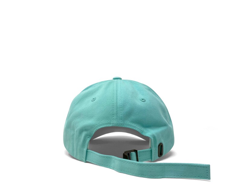 Custom embroidered script hat with personalized text on teal cotton twill dad cap featuring unstructured low profile shape and adjustable strap closure. Clean stitched lettering design on front panel suitable for branding, custom text display and everyday wear. Soft breathable cotton fabric with curved visor and detailed embroidery finish.