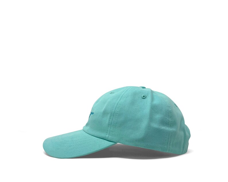 Custom embroidered script hat with personalized text on teal cotton twill dad cap featuring unstructured low profile shape and adjustable strap closure. Clean stitched lettering design on front panel suitable for branding, custom text display and everyday wear. Soft breathable cotton fabric with curved visor and detailed embroidery finish.