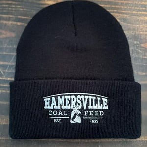 May include: Black knit beanie with a white embroidered logo that reads "Hamersville Coal Feed Est 1933".