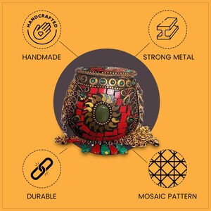 Puede incluir: Una caja de metal roja, negra y dorada con un patr&oacute;n de mosaico y una cadena de cuentas. La caja est&aacute; hecha a mano y presenta una piedra preciosa verde. La caja est&aacute; etiquetada como "Artesanal" y "Metal fuerte".