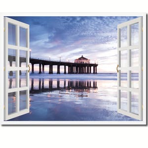 May include: A view of a pier extending out into the ocean with a building at the end. The pier is reflected in the water. The sky is a light blue with clouds. The image is framed by a white window with the window open.