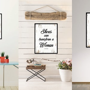 May include: Three framed prints with a white background and black text that reads "Shoes can transform a Woman". The prints are hanging on a white wall with wood paneling.