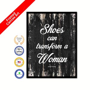 May include: Black and white framed canvas print with a distressed wood background. The text "Shoes can transform a Woman" is written in white cursive font with the name "manolo blahnik" written in smaller white font below.
