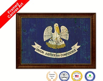 May include: Framed canvas print of the Louisiana state flag. The flag features a white pelican with yellow wings and a yellow nest with baby pelicans. The flag is on a blue background with the words "Union Justice and Confidence" in a white banner.