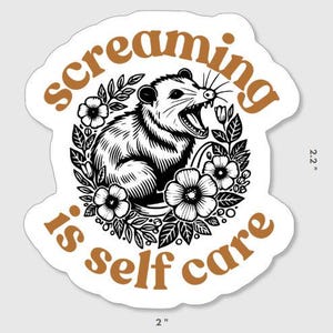 May include: A white sticker with a black and white illustration of an opossum with a floral design. The text "Screaming is self care" is written in brown letters around the opossum.