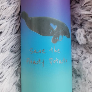 May include: A blue and purple ombre water bottle with a silhouette of a manatee and the text "Save the Floaty Potato".