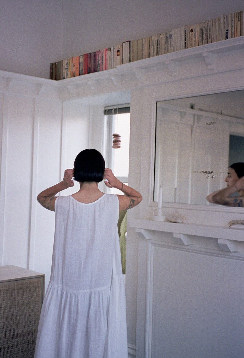 White linen sleeveless dress with ruffled hem
