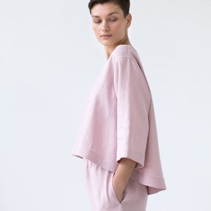 May include: A light pink linen top and shorts set. The top has a relaxed fit and a slightly cropped hem. The shorts have a drawstring waist and pockets.