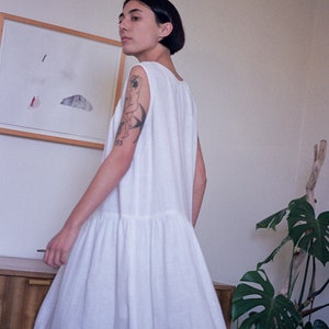 White linen sleeveless dress with ruffled hem