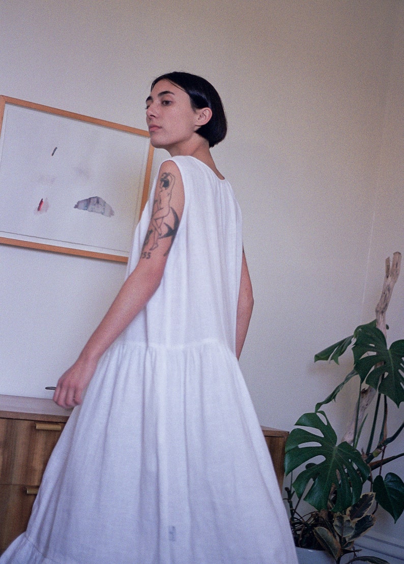 White linen sleeveless dress with ruffled hem