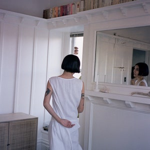 White linen sleeveless dress with ruffled hem