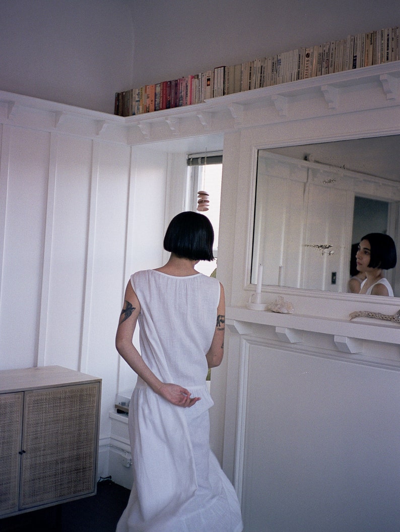 White linen sleeveless dress with ruffled hem