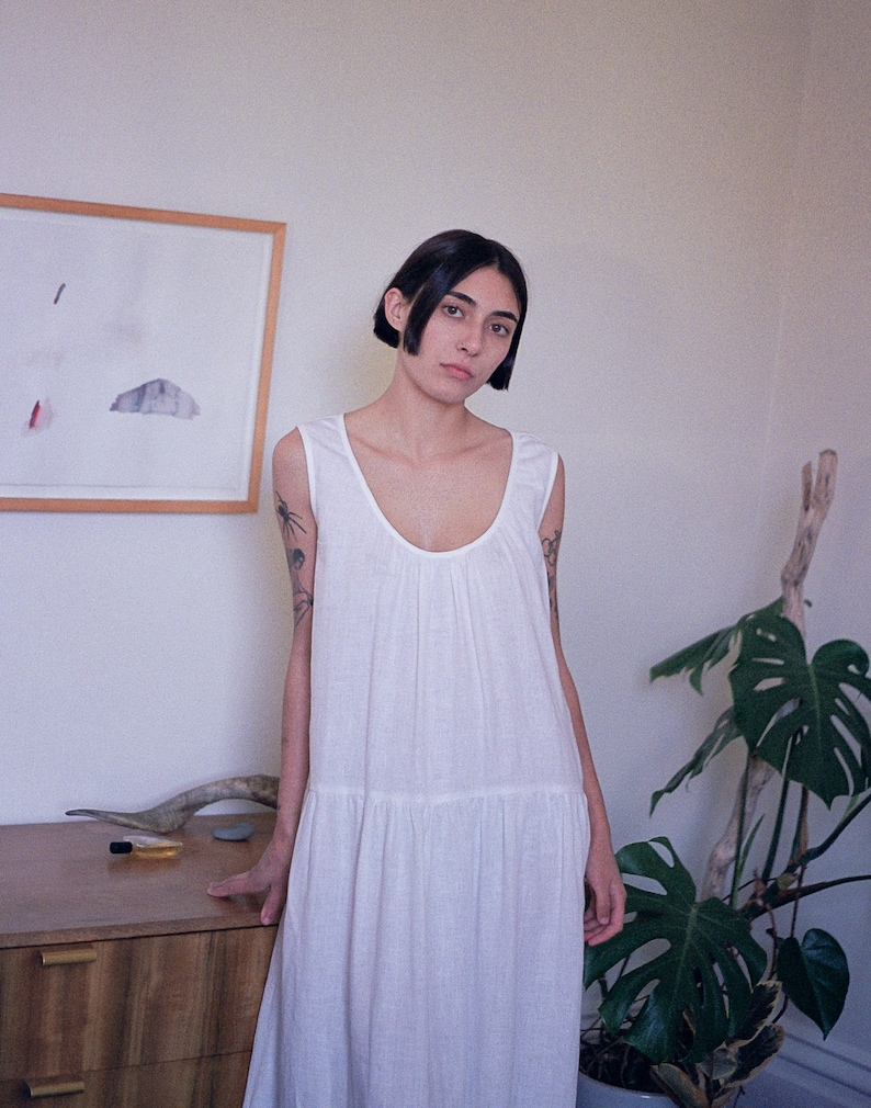 White linen sleeveless dress with ruffled hem