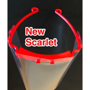 May include: Red plastic face shield with a clear visor. The shield has a headband that goes over the head. The text "New Scarlet" is printed on the shield.