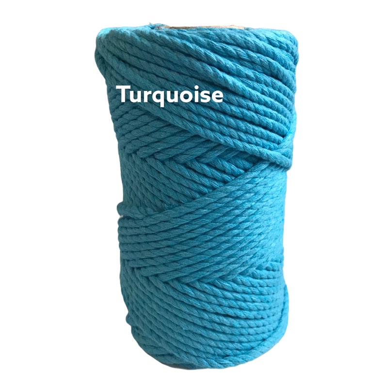 May include: A spool of turquoise macrame cord featuring a thick, braided cotton construction. The word Turquoise is printed in white text on the front of the vibrant blue fiber, which is wound into a cylindrical shape with visible rope texture.
