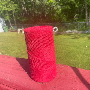 May include: A roll of red cotton rope, wound tightly and ready for crafting projects.