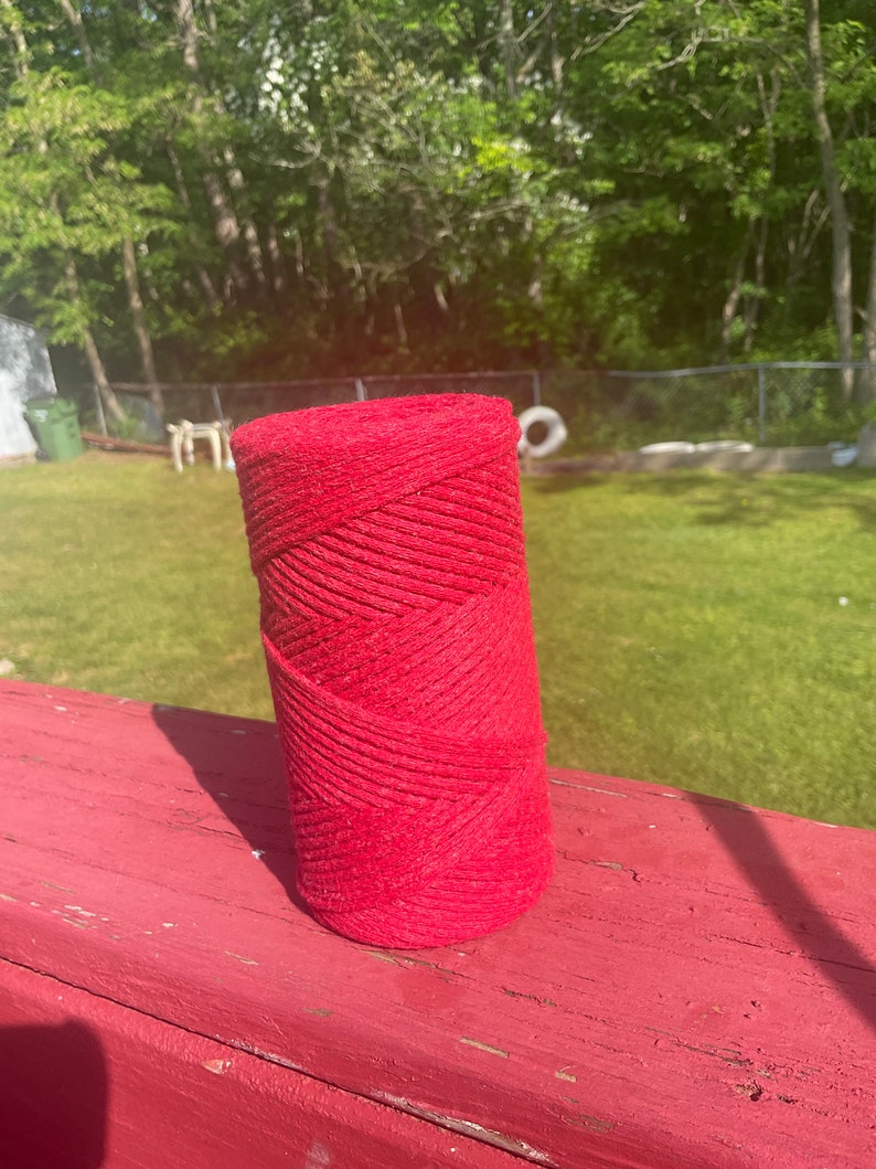 May include: A roll of red cotton rope, wound tightly and ready for crafting projects.