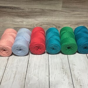 May include: Six spools of cotton rope in various colors. The spools are arranged in a row from left to right: light pink, light blue, red, teal, green, and dark teal.