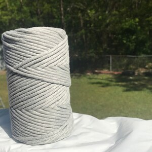 Pode incluir: Um rolo de corda de algod&atilde;o cinza, perfeito para projetos de artesanato.