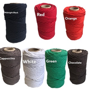 May include: Seven spools of twisted cotton cord arranged in two rows. The colors include Midnight Black, Red, Orange, Cappuccino, White, Green, and Chocolate. Each spool features a cardboard center core and a thick, textured rope construction.