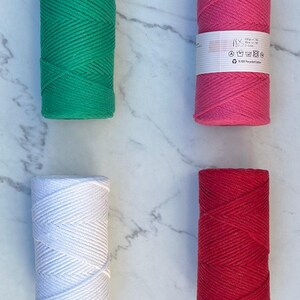 May include: Four spools of 100% recycled cotton cord in green, pink, white, and red. Each spool is approximately 200 grams and 50 meters long.
