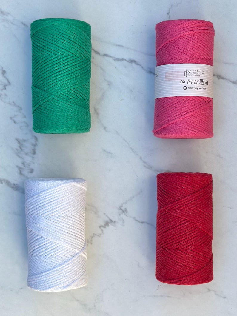 May include: Four spools of 100% recycled cotton cord in green, pink, white, and red. Each spool is approximately 200 grams and 50 meters long.