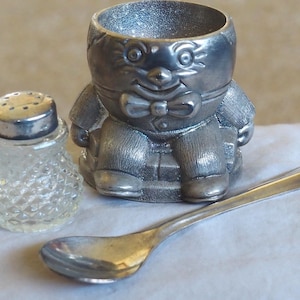 Juego vintage de huevera, salero y cuchara de Humpty Dumpty. Bañado en plata.