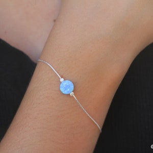 Könnte beinhalten: Ein zartes Armband aus Silberkette mit einem Anhänger aus hellblauem Opal.