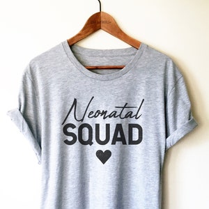 May include: A gray t-shirt with the text "Neonatal Squad" and a black heart.