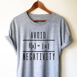 May include: Gray t-shirt with black text that reads "AVOID f(x) = |x| NEGATIVITY".
