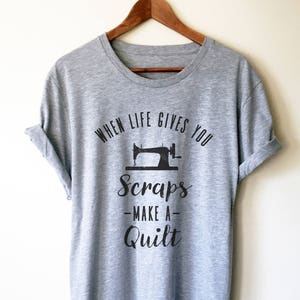 May include: Gray t-shirt with a black graphic of a sewing machine and the text "When life gives you scraps - make a quilt".