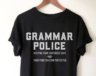Könnte beinhalten: Schwarzes T-Shirt mit weißem Text, der "Grammar Police" und "Keeping your sentences safe -and- your punctuation protected." lautet.