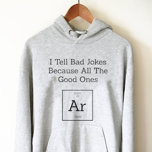 May include: Gray hooded sweatshirt with the text "I Tell Bad Jokes Because All The Good Ones" and a graphic of the periodic table element Argon (Ar).