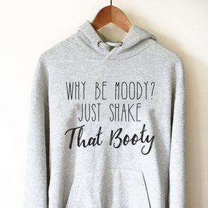 May include: Gray hooded sweatshirt with the text "Why be moody? Just shake that booty" printed on the front.