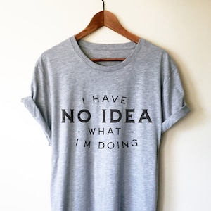 May include: A heather grey t-shirt with the text "I have no idea what I'm doing" printed in black.
