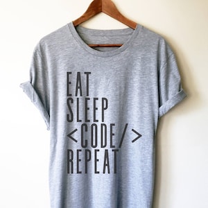 May include: Grey t-shirt with black text that reads "Eat Sleep <Code/> Repeat".