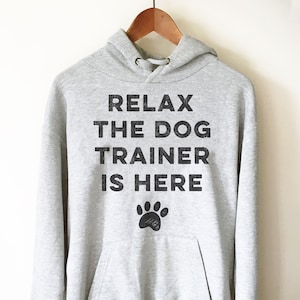 Felpa con cappuccio The Dog Trainer Is Here - Maglietta per addestramento cani, Maglietta per addestratore cani, Maglietta per cani, Regalo per addestramento cani, Maglietta per papà cani, Maglietta per amanti dei cani