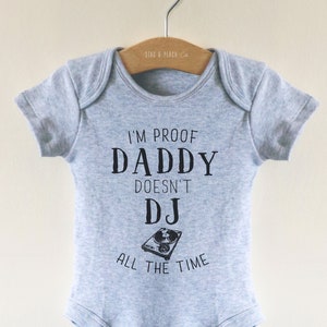 May include: Gray baby onesie with the text "I'm proof Daddy doesn't DJ all the time" and a black and white illustration of a record player.