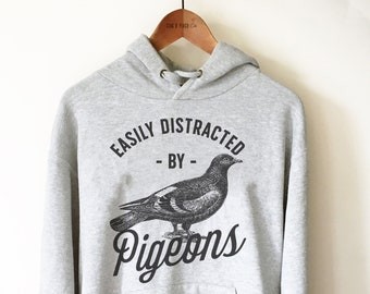 May include: A gray hooded sweatshirt with a black graphic print of a pigeon and the text "Easily Distracted - By - Pigeons".
