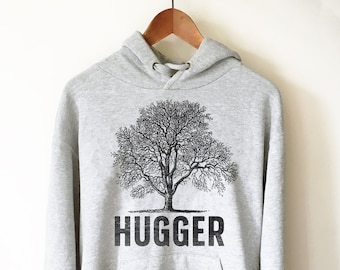 May include: A grey hooded sweatshirt with a black tree graphic and the word "HUGGER" printed below it.