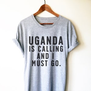 May include: Gray t-shirt with black text that reads "Uganda is calling and I must go."