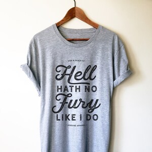 Puede incluir: Una camiseta gris jaspeada con un estampado gr&aacute;fico negro que dice "Hell hath no fury like I do" y el texto "Stag & Peach Co." y "Genuine Apparel".