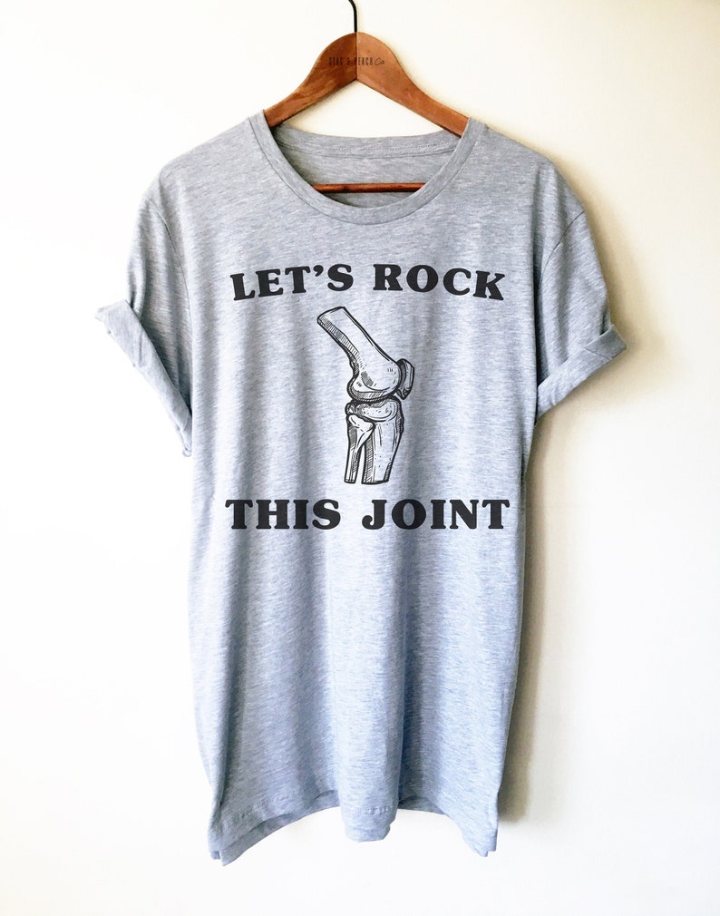 May include: Gray t-shirt with a black graphic of a knee bone and the text "Let's Rock This Joint".