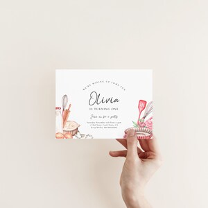 Pu&ograve; includere: Un invito bianco con un'illustrazione ad acquerello di utensili da cucina. Il testo recita "We're mixing up some fun Olivia is turning one Join us for a party Saturday November 6th from 4-6pm Chef Lane, Cook Town, CA Rorp Mickey 888-555-5555"