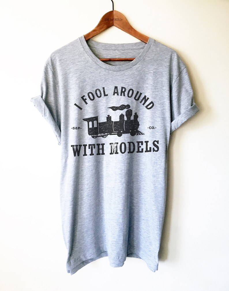 May include: A gray t-shirt with a black print of a train and the text "I fool around with models -S.S.P.- -CO.-".