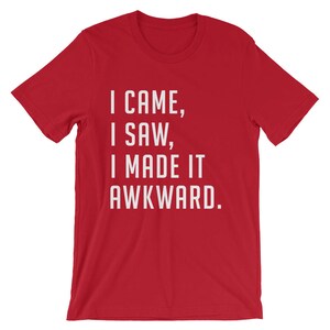 Puede incluir: Camiseta roja con el texto blanco "I CAME, I SAW, I MADE IT AWKWARD." La camiseta de manga corta est&aacute; hecha de un material suave y tiene cuello redondo. El texto est&aacute; centrado en la parte delantera de la camiseta.